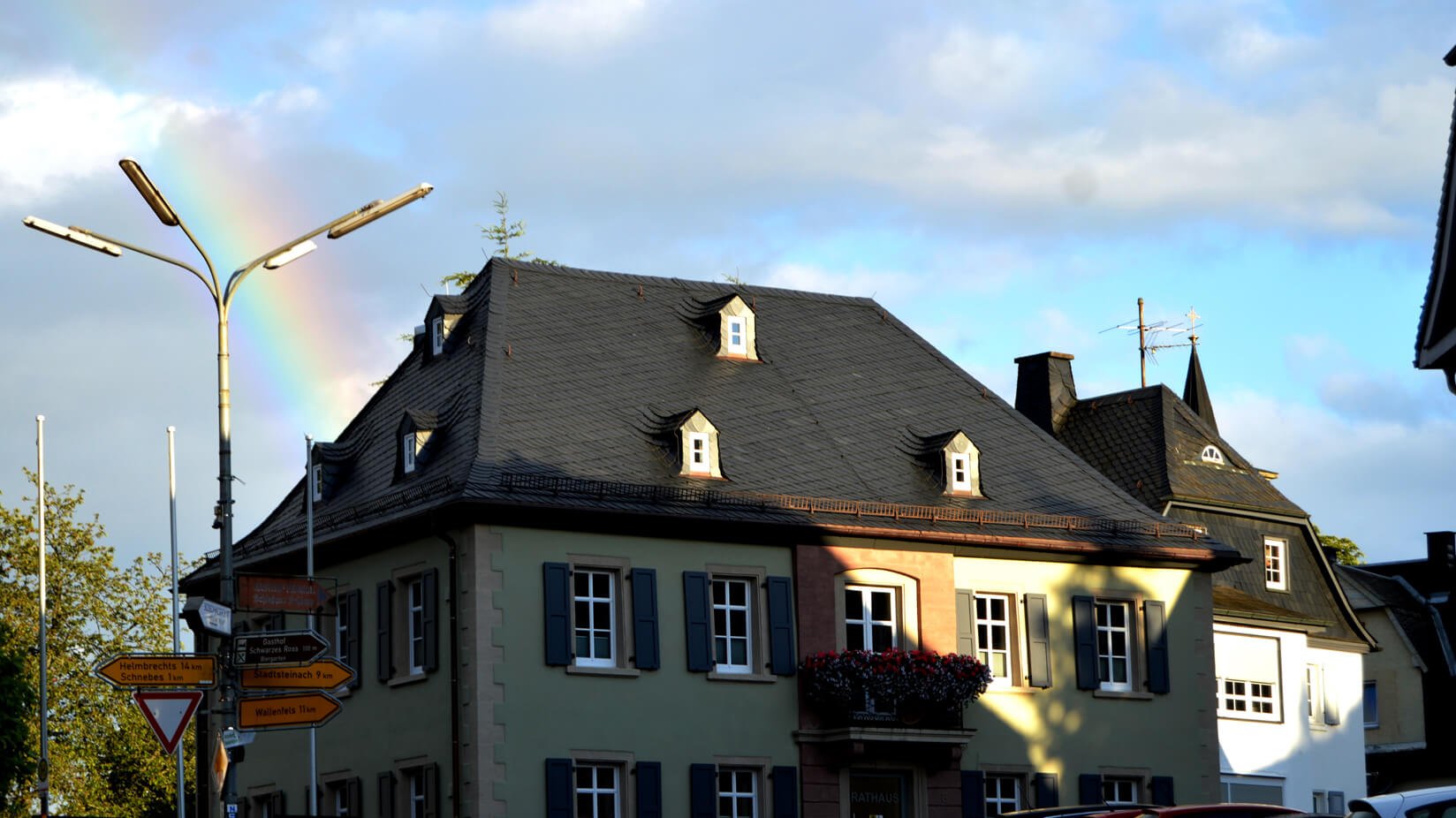 Rathaus Presseck mit Regenbogen und blauer Himmer